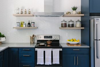 A kitchen with a stove top oven and a refrigerator.